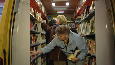 ältere Damen suchen Bücher in Bus aus