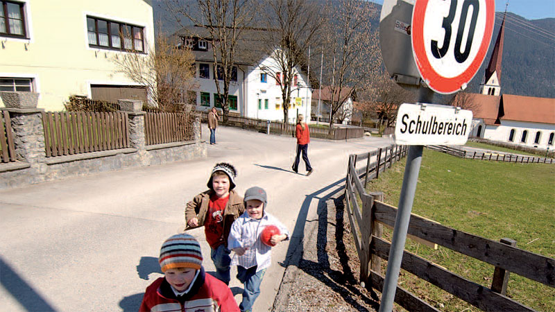 Schulkinder vor Straßenschild mit Tempo 30